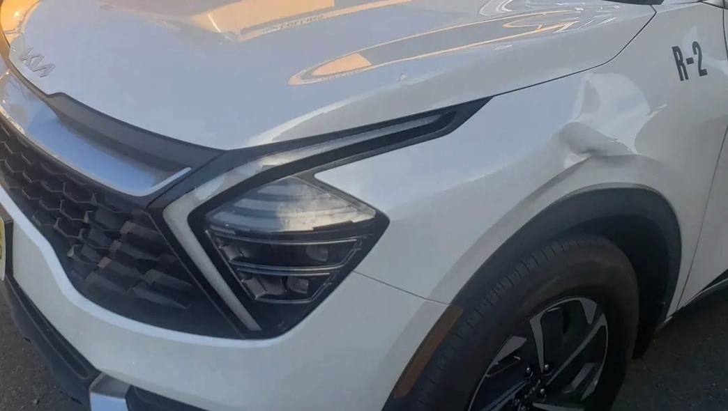 Front-end collision damage on a white Kia Sportage before repair at Mickey's Auto Body near Harrison, NJ