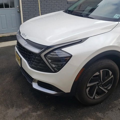 After: the same white Kia Sportage with the front end rebuilt and repainted