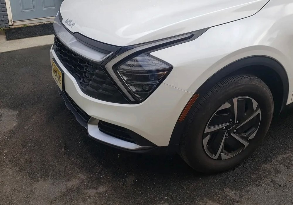 White Kia Sportage with the front end repaired and refinished at Mickey's Auto Body