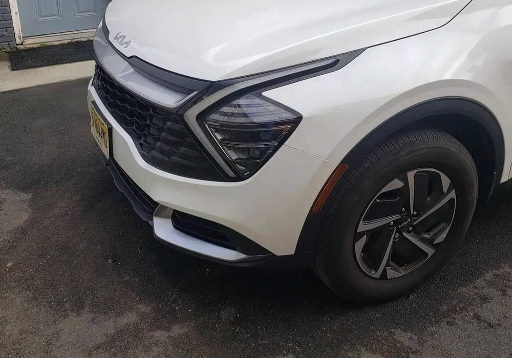 White Kia Sportage with the front end repaired and refinished after collision repair at Mickey's Auto Body in Kearny, NJ