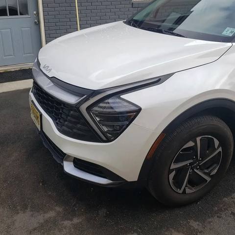 After: the same white Kia Sportage with the front end rebuilt and repainted