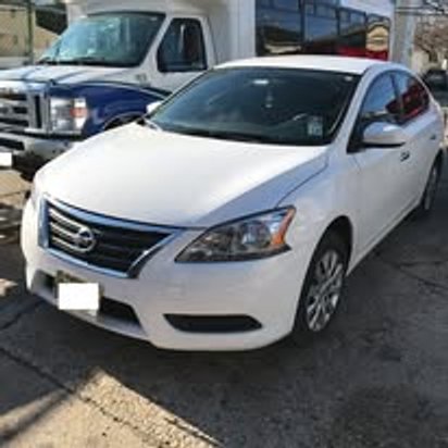 After: the same white Nissan Sentra repaired and refinished at Mickey's Auto Body