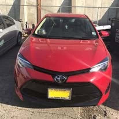 After: the same red Toyota Corolla with the front end rebuilt and repainted