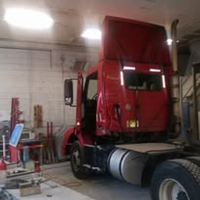 Red Volvo semi tractor in the bay during commercial collision repair, Kearny NJ