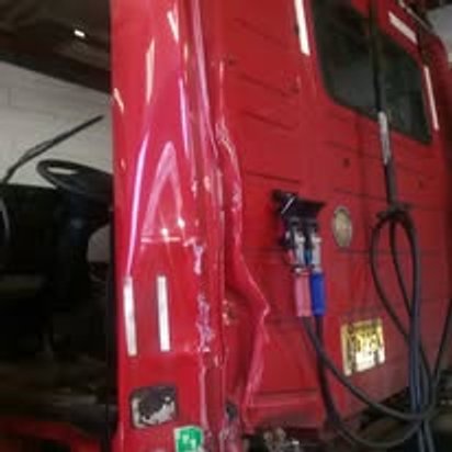 Before: torn cab panel on a red Volvo semi tractor, Kearny NJ